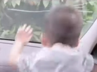 孩子在房車前座蹦跳哭鬧時，將車頭玻璃撞裂了。影片截圖