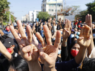 群眾舉起象徵反抗極權統治的三指手勢，抗議軍事政變。AP圖片