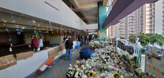 墮樓現場有大量由致祭人士放下的白花和寓意祝福的紙鶴。