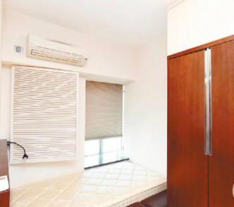 寢區設於客廳一隅，於窗邊放有單人牀及入牆式衣櫃，更節省空間。