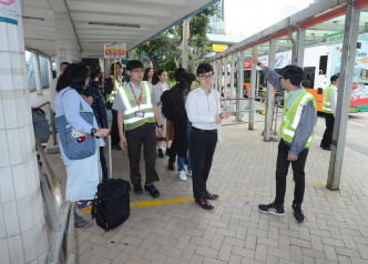 工作人员在站头协助乘客。