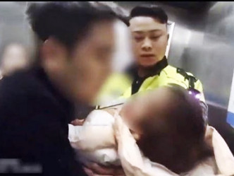 警员将女童抱在怀内，从门口一路送进急症室电梯。网图