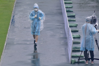 赛事在豪雨下进行，工作人员需穿上防护衣及雨衣工作。梁柏琛摄
