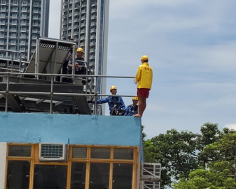 救生員站在欄桿外企圖從高處跳下。梁國峰攝