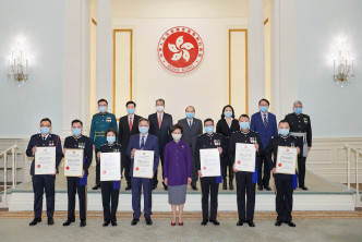 林郑月娥向7名现任和前任高级警务人员颁奖状，以表扬他们就维护国家安全的重大贡献。政府新闻处