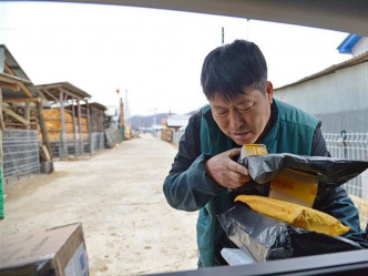 若電單車馱不下，金仁哲即使開自己的車，也要送到。  新華社圖片