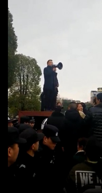 榮縣縣長鄭小清被迫高舉喇叭對人群喊話。網上圖片
