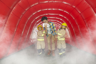小朋友可穿越模拟火警现场的烟雾体验区救出火场中扮演灾民的家长。