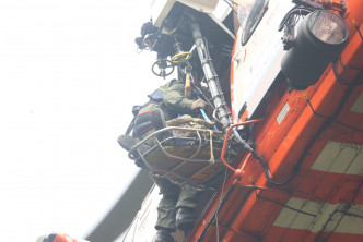 救援人员为伤者固定伤势后，由直升机吊运送往医院治理。