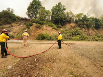 当地消防人员为扑救山火疲于奔命。AP图