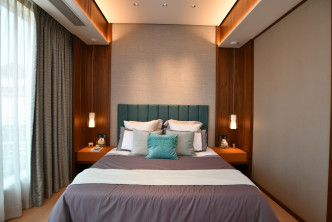 主人房中置的雙人床配以藍綠色的絨面床頭靠墊及兩側的吊燈。