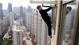小偷爬出窗外想从23楼逃跑。网图
