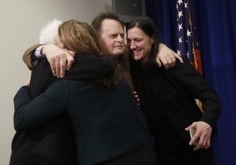 哈德曼在裁决宣布后，拥抱妻子和律师团队成员。美联社图片