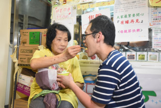 Calvin挖出僅餘兩球雪糕，與母親一同分享。尹敬堂攝