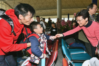 林鄭月娥在機場向市民及旅客拜年，並派朱古力及合照。新聞處