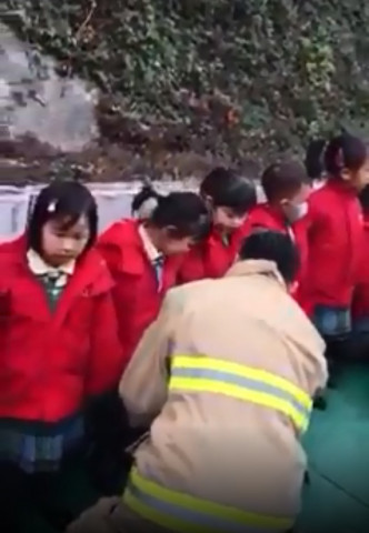 消防员先后安抚遇车祸学童。网上图片