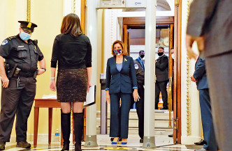 佩洛西在众议院会议厅外，穿越一台新设的金属探测器。