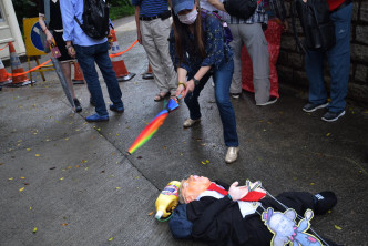 「同心護港」成員以雨傘擊打特朗普的人型玩偶。