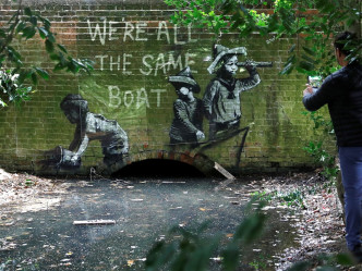 奥尔顿镇出现的涂鸦描绘3小童坐在一艘小艇上。REUTERS