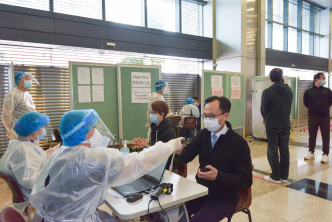 聂德权（右三）正准备接受病毒检测服务。政府新闻网图片