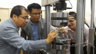 科研團隊人員使用機器測試「超級鋼」的延展性及強度。