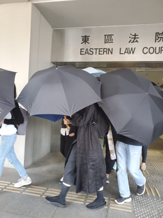 被告丘子樂時步出多人開遮雨傘遮擋。 黃雅純攝