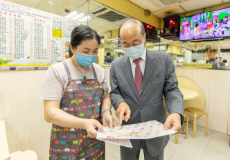 尹志田（右）向参与食肆的负责人介绍「关怀有饍」计划。