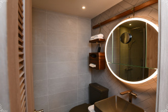 浴室設計時尚，設配合滲光燈的圓鏡。（1B座48樓A室經改動示範單位）