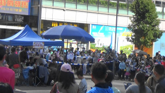 眾演員喺籃色帳篷下食Lunch，旁邊有過百街坊圍住陪食。