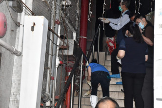 政府化驗師人員在一樓梯間鐵柱血掌印及 扶手梯地面套取血漬。