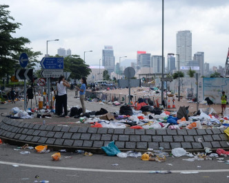 政府总部附近一带街道遗下如大堆雨伞、口罩等杂物仍未清理好。