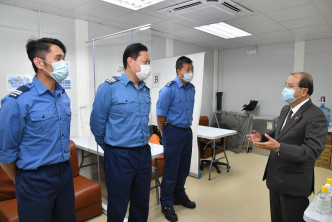 张建宗（右一）与驻守检疫中心的消防处人员交谈。政府新闻处图片