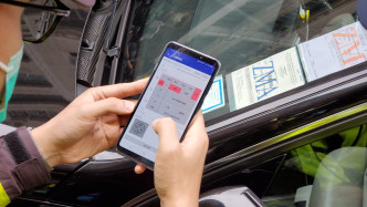 交通督導員在長沙灣青山道與通州西街交界執勤，向傳媒示範發出電子告票的行動。
