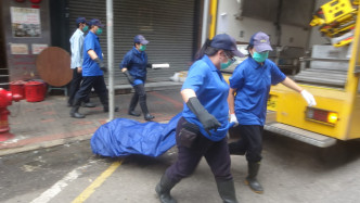 仵工抬走女子遺體。