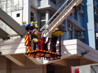 消防架起升降台将遗体移到到地面。