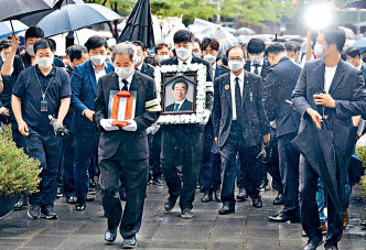 悼念者周一在喪禮上持朴元淳的肖像。