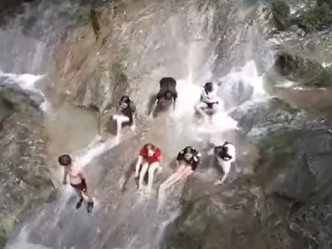 不少游客在出事前坐在瀑在的岩石上。 （片段截图）