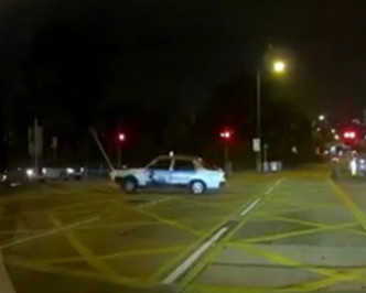 一辆红色的士撞到路中心的告示牌和安全岛灯箱。Linda Hui fb片段截图