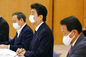 日本首相安倍晋三（中）。AP资料图片