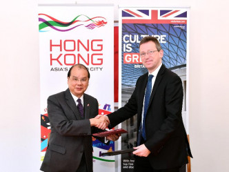 張建宗（左）與衛俊明（右）簽署香港及英國文化合作諒解備忘錄後握手。