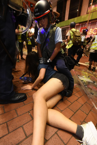 有女子被警员按在地上。