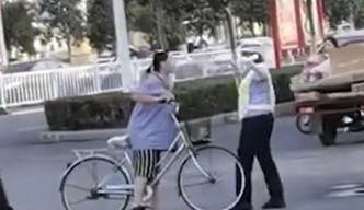 女子在路上逆線踩單車被截停，竟出手打傷女輔警。網圖