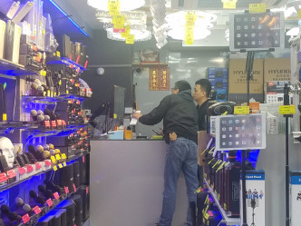 探員在案發現場附近查閱其他店鋪的閉路電視。