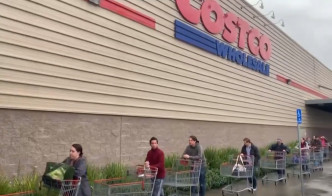 美國加州costco超市門口，人們推著大型購物車，未戴口罩，在超市門前排起了長隊。(網圖)
