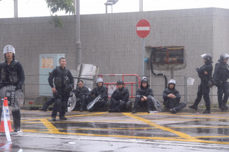 部分警员累倒，坐在地上休息。