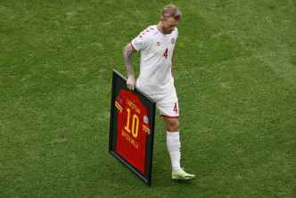 丹麦队长卡积亚手持威尔斯给基斯甸艾历臣打气的球衣。AP