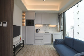 開放式廚房廚櫃用上灰白色雲石面，為單位增添高貴氣派。（28樓B室）