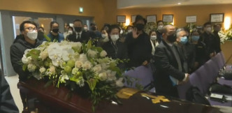 靈柩上放了白色鮮花。