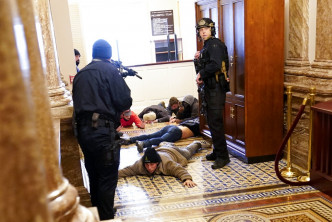 示威者闯入国会大肆捣乱，警员持枪驱散。AP图片