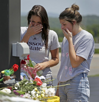 有市民献花后为死者伤心难过后。AP